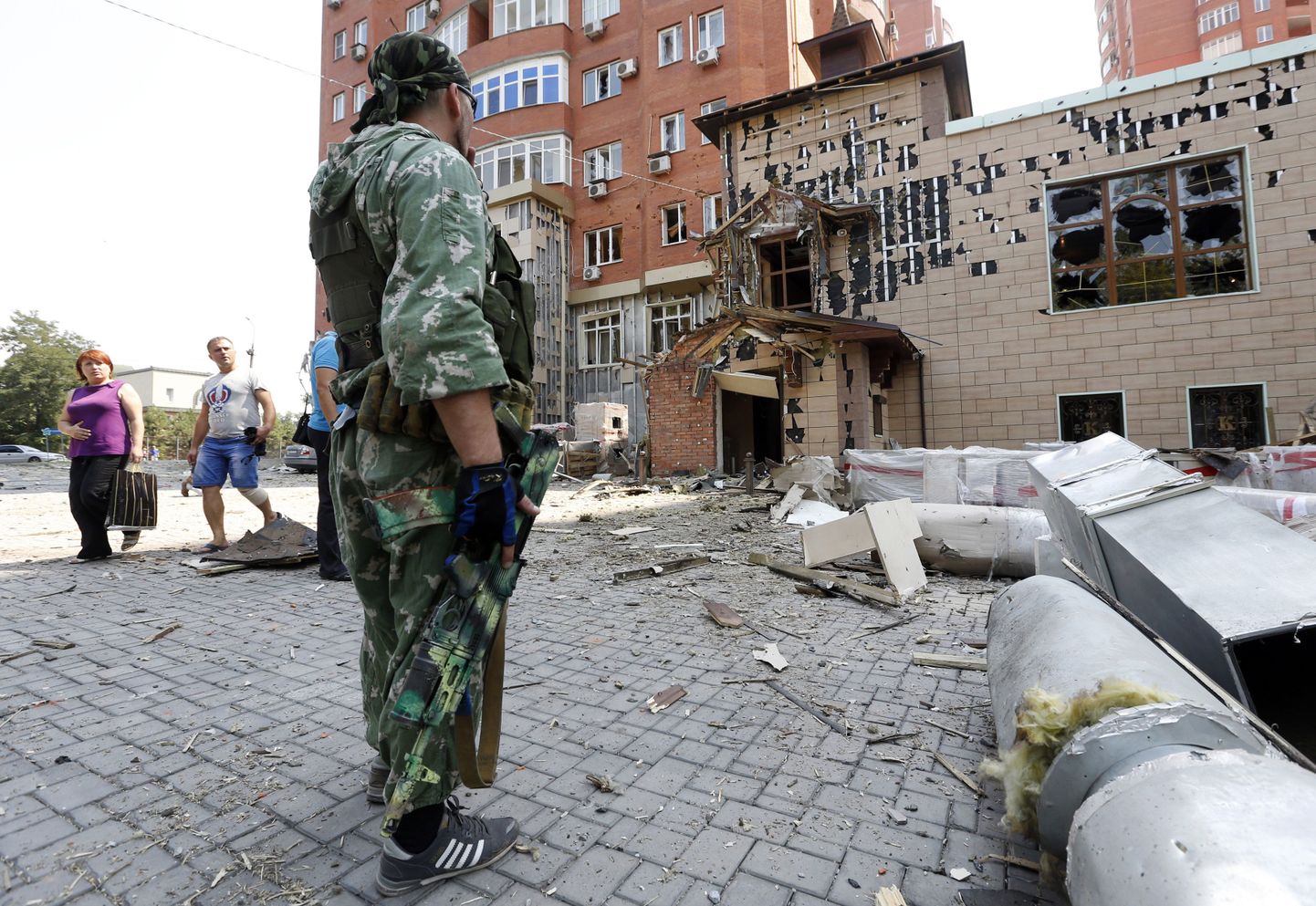 Военный ДНР у жилого дома в Донецке, разрушенного войной (7.08).