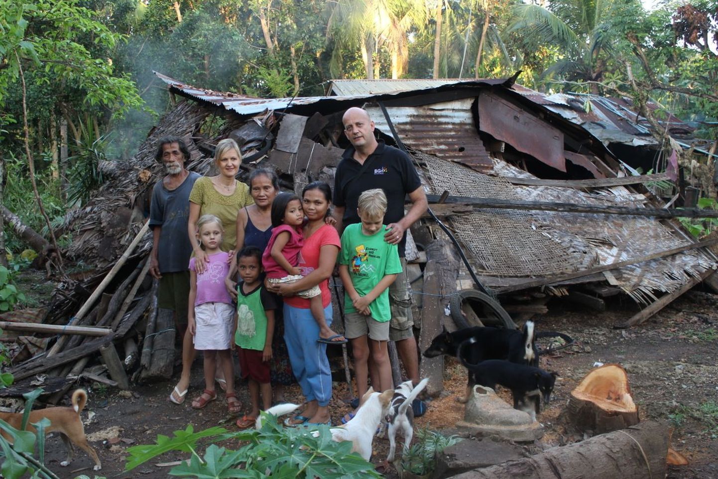 Foto Birgit Naurist ja Robin Gurney’st hiljutises taifuunis hävinud maja taustal Andas, milles elanud perekonda üritatakse aidata uue maja ehitamisel ja valguspudelite paigaldamisel.