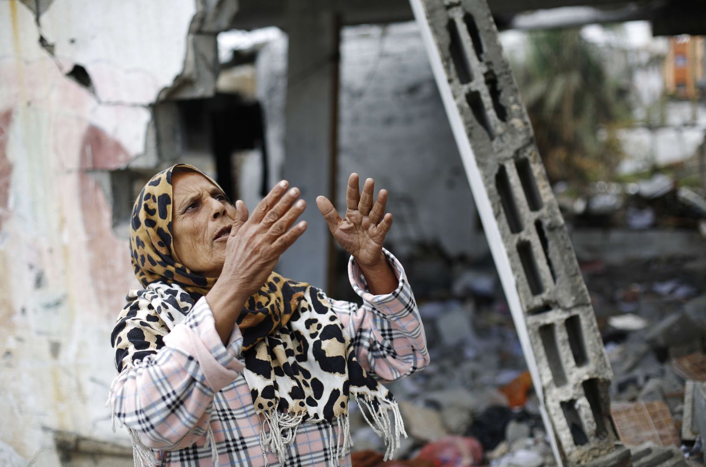Purustatud kodu kõrval seisev naine Gaza sektoris.