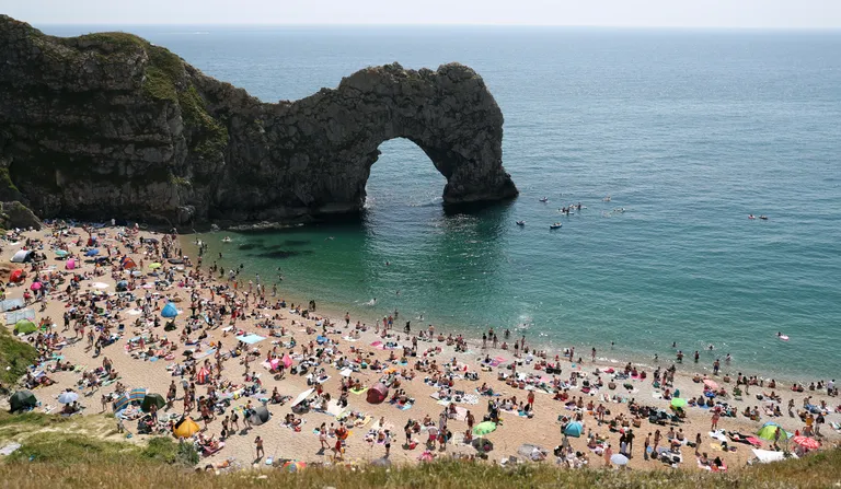 Dorseti maakonnas asuv rand ja Durdle Door kaljukaar. Pilt on tehtud laupäeval, 30. mail, kui randa oli kogunenud hulgaliselt inimesi. Neli noormeest otsustasid tol päeval kaljukaarelt vette hüpata.