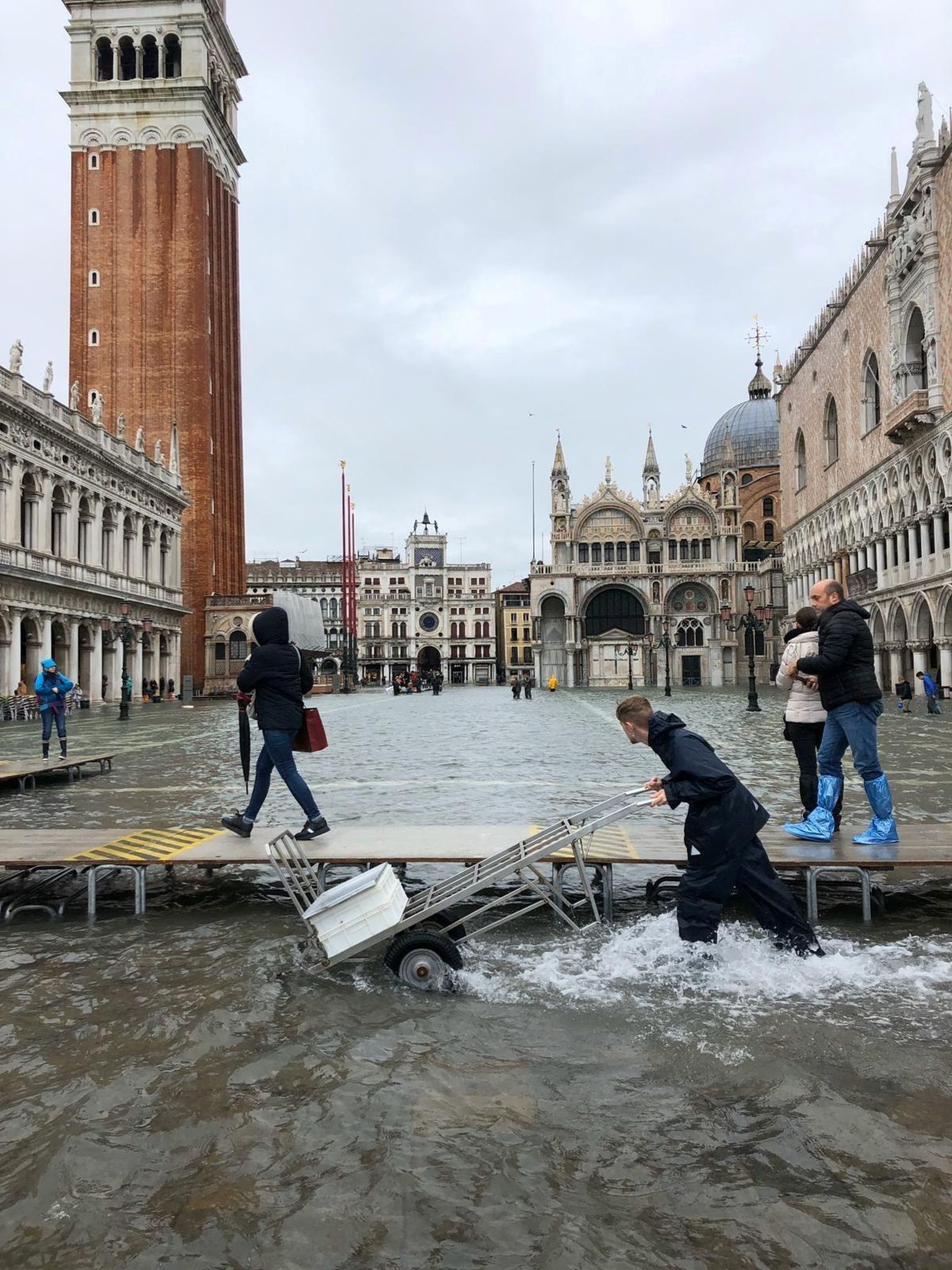 Mees lükkab transpordikäru üleujutatud Veneetsias. 