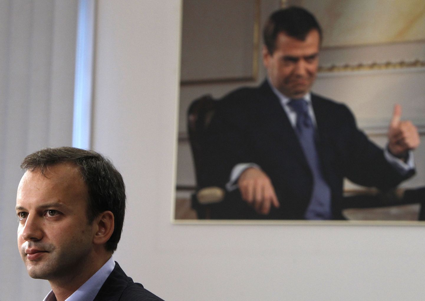 Arkadi Dvorkovitš (esiplaanil). Tagaplaanil pilt president Dmitri Medvedevist.