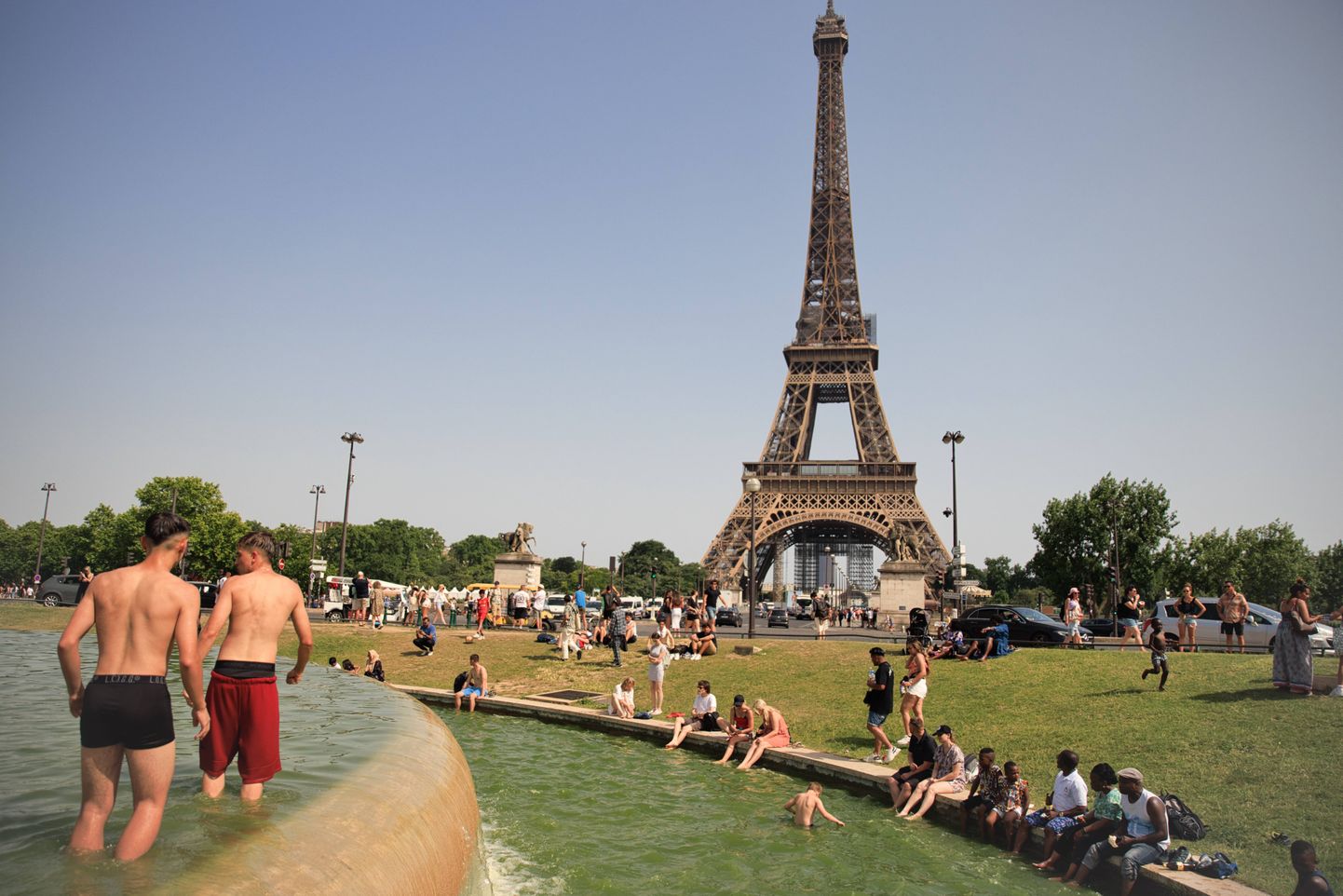 Inimesed Eiffeli torni juures purskkaevus jahutust otsimas.