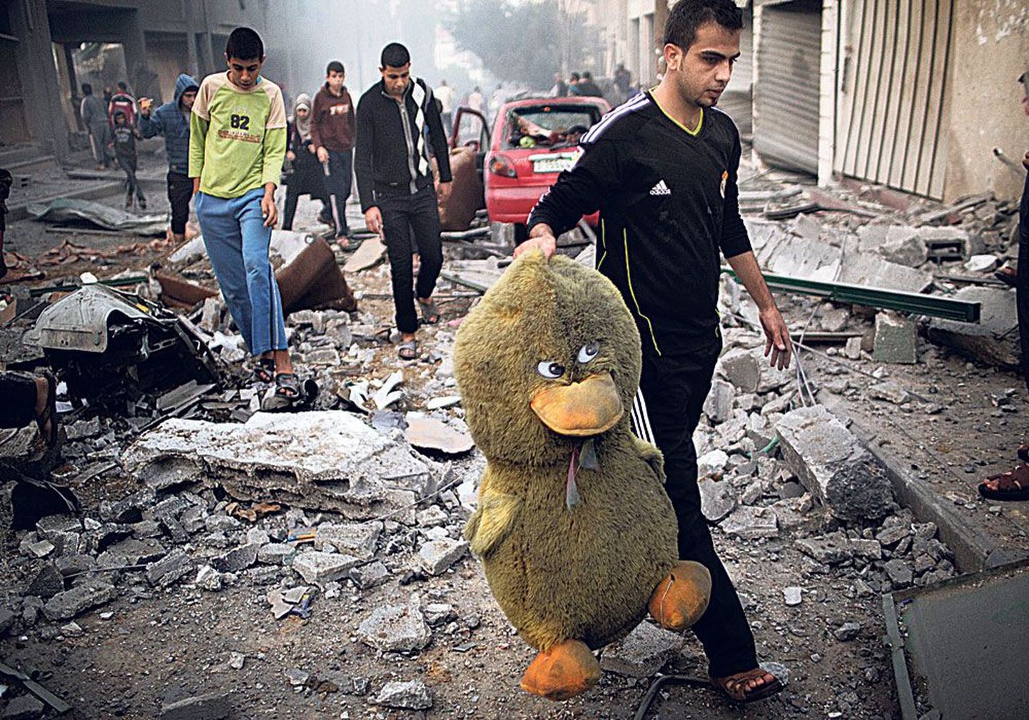 Палестинец с большой мягкой игрушкой после налета на Газу израильской авиации.