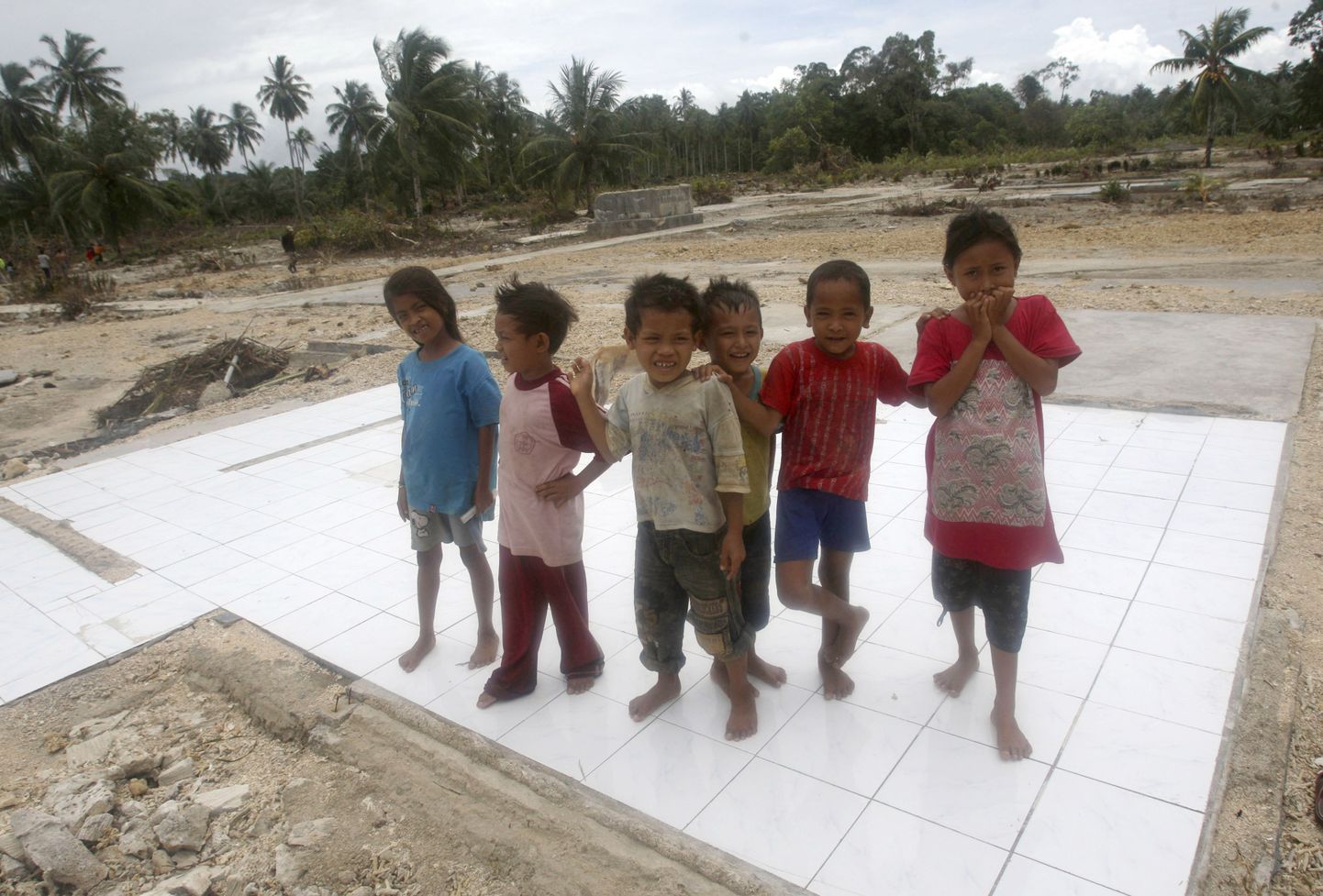Indoneesia lapsed seisavad maja põrandal. Küla tabanud hiidlaine uhtus merre kümneid maju.