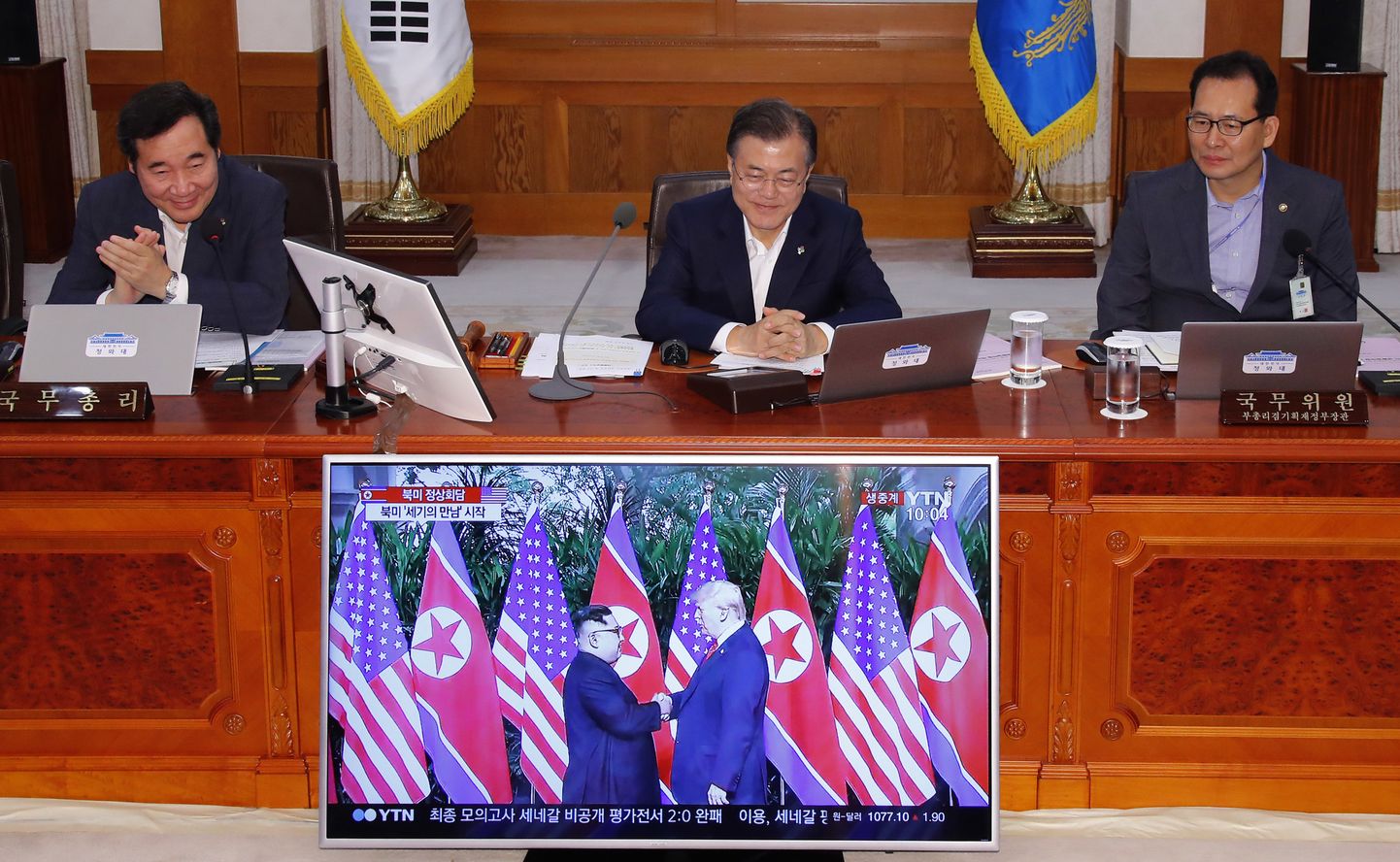 Lõuna-Korea president Moon Jae-in. Tema ees teleekraanil on ülekanne USA president Donald Trumpi ja Põhja-Korea juhi Kim Jong-uni kohtumisest.