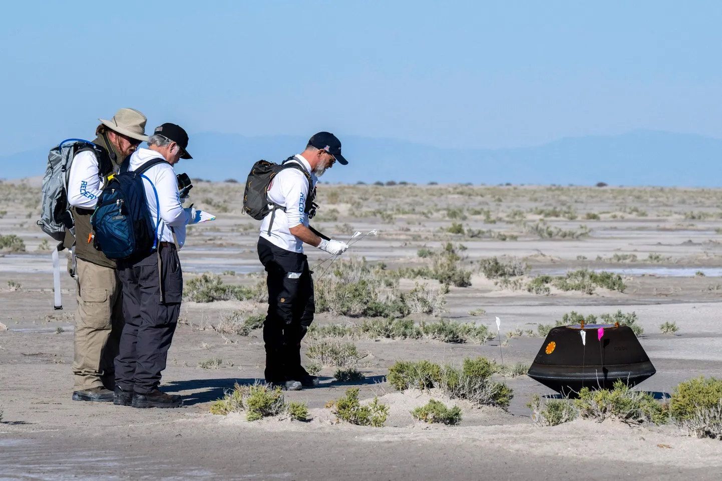 Osiris-Rexi maandumiskapsel Utah kõrbes. Vasakult: NASA astromaterjalide kuraator Francis McCubbin, NASA proovide tagastamise kapsli teadusjuht Scott Sandford ja Arizoni ülikooli Osiris-Rexi peateadur Dante Lauretta koguvad andmeid 24. septembril 2023, vahetult pärast seda, kui NASA Osiris-Rexi missiooni proovide tagastamise kapsel maandus Pentagoni treeningala Utah kõrbes. Teadlased loodavad, et kosmoselaeva pardal olev asteroidiproov annab inimkonnale parema arusaama meie Päikesesüsteemi kujunemisest ja sellest, kuidas Maa muutus elamiskõlblikuks.