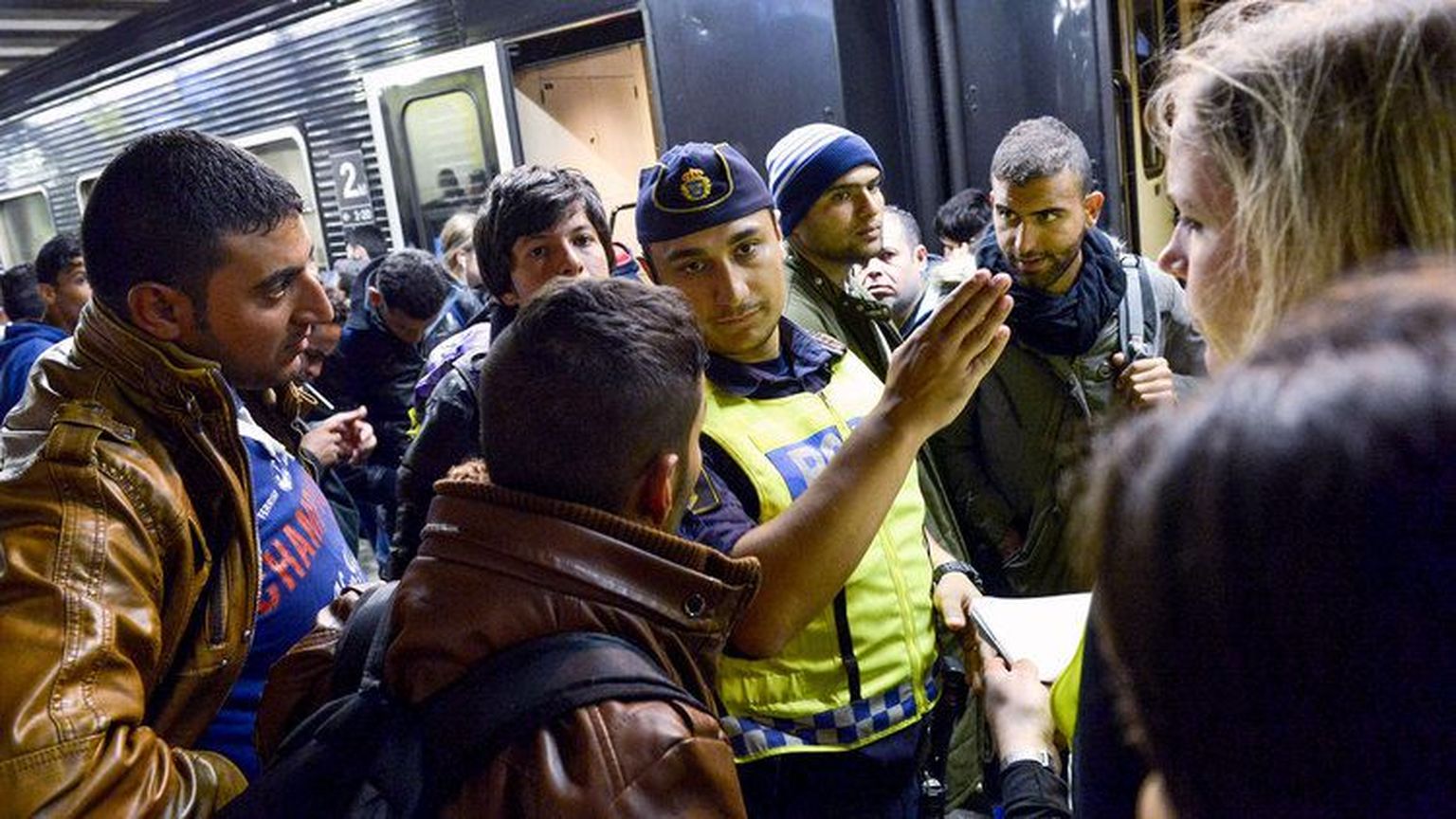 Politseiohvitser septembris Stockholmi raudteejaamas Malmöst saabunud migrante juhendamas.