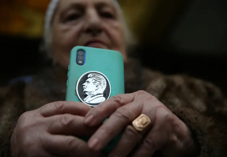 Женщина показывает смартфон украшенный профилем Сталина, родина советского диктатора, Гори, Грузия, 5 марта 2023 года.