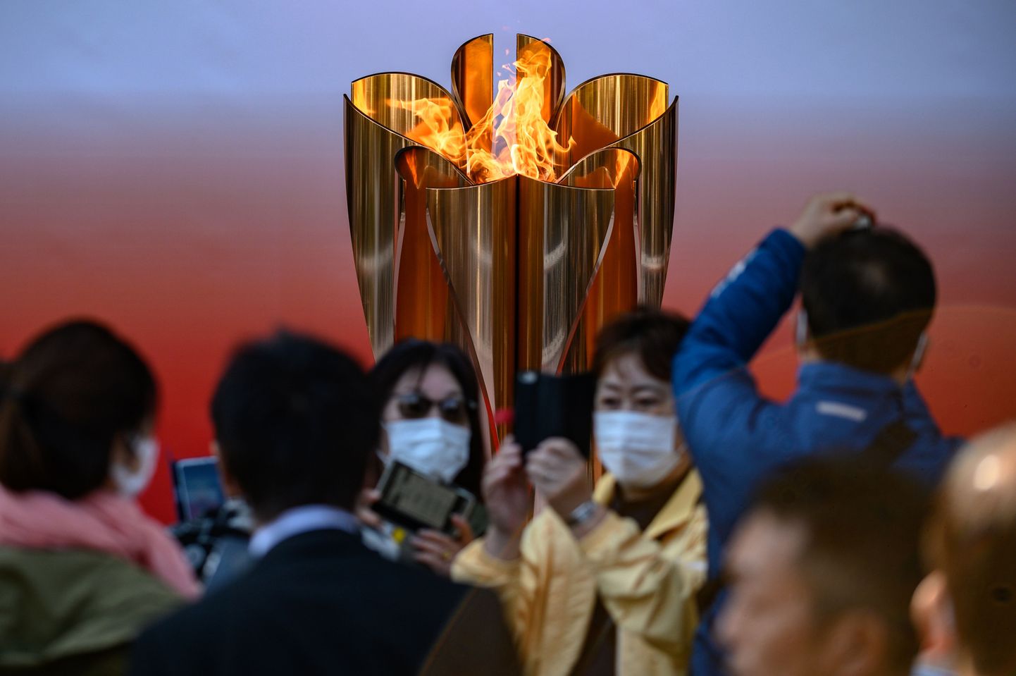 Jaapanlased Tokyo olümpiamängude tule juures pildistamas.