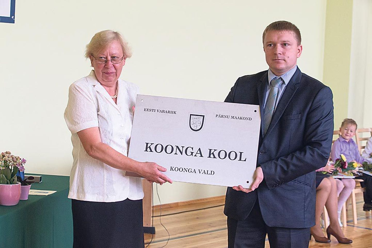 Koonga vallavanem Mikk Pikkmets andis Koonga kooli direktorile Ülle Andreale kooli uue nimesildi.