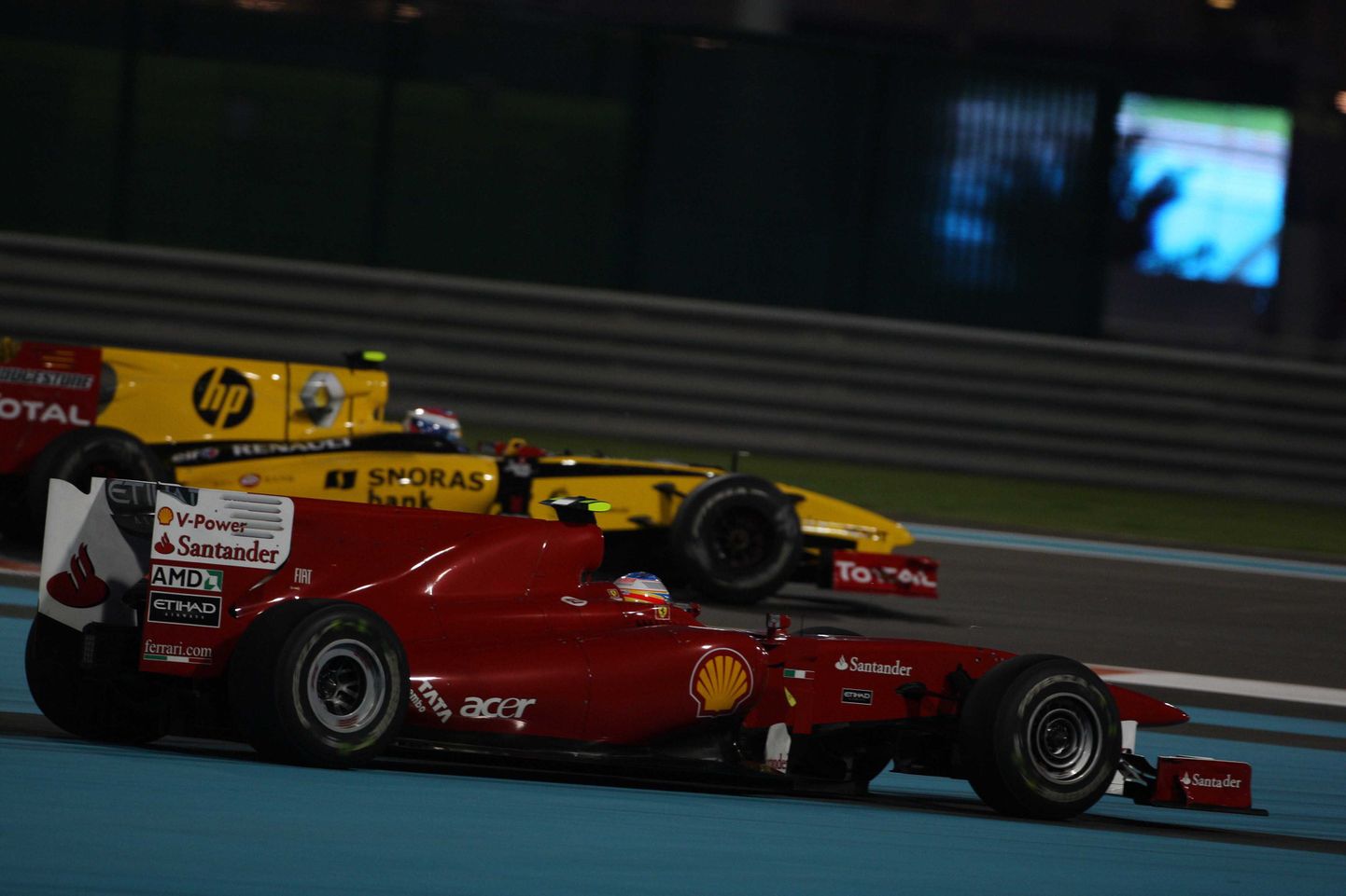 Ferrari Фернандо Алонсо (на переднем плане) и Renault Виталия Петрова.