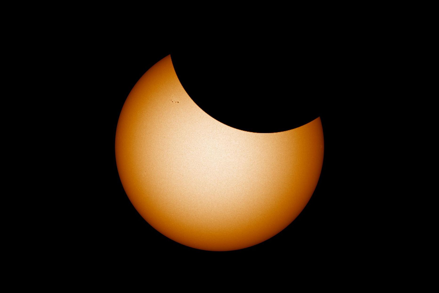 Selline võiks teleskoobis välja näha homne päikesevarjutus oma tipphetkel. Foto Päikesest on tehtud 30. mail ning sellel on näha ka mõned pisikesed päikeseplekid, mis on homseks liikunud Päikese paremasse serva või sootuks kadunud. Loodetavasti on selleks ajaks mõni uus juurde tekkinud. 