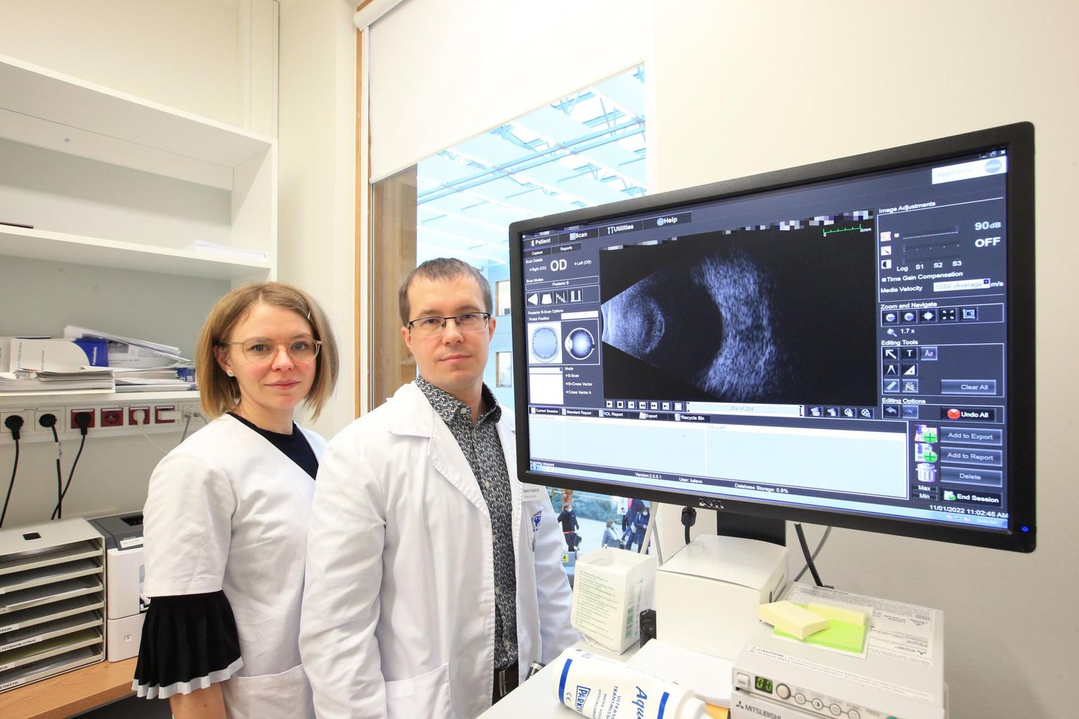 TÜK silmakliiniku juhataja Mikk Pauklin seisab koos silma­arst Laura Mauringuga vaatlustoas ultraheliaparaadi kõrval, kus kontrollitakse patsiente nii enne kui ka pärast operatsiooni.