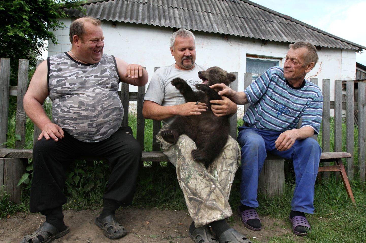 Kohalikud Venemaal Atirka külas karupojaga.