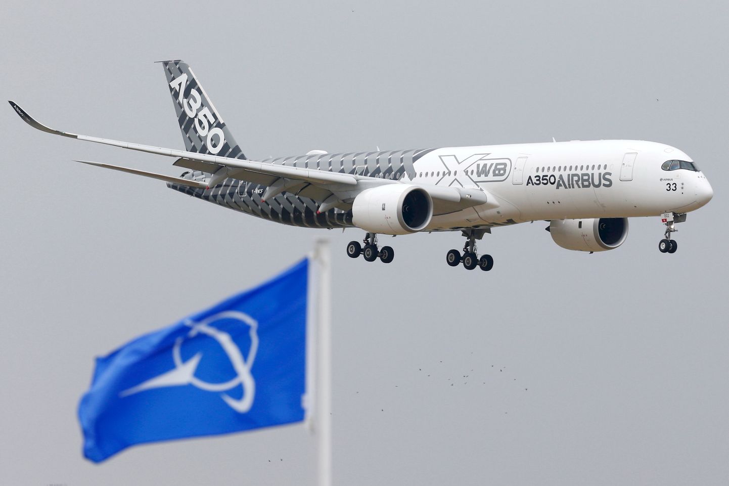Airbus A350 reisilennuk lendamas Boeingu lipu kohal.