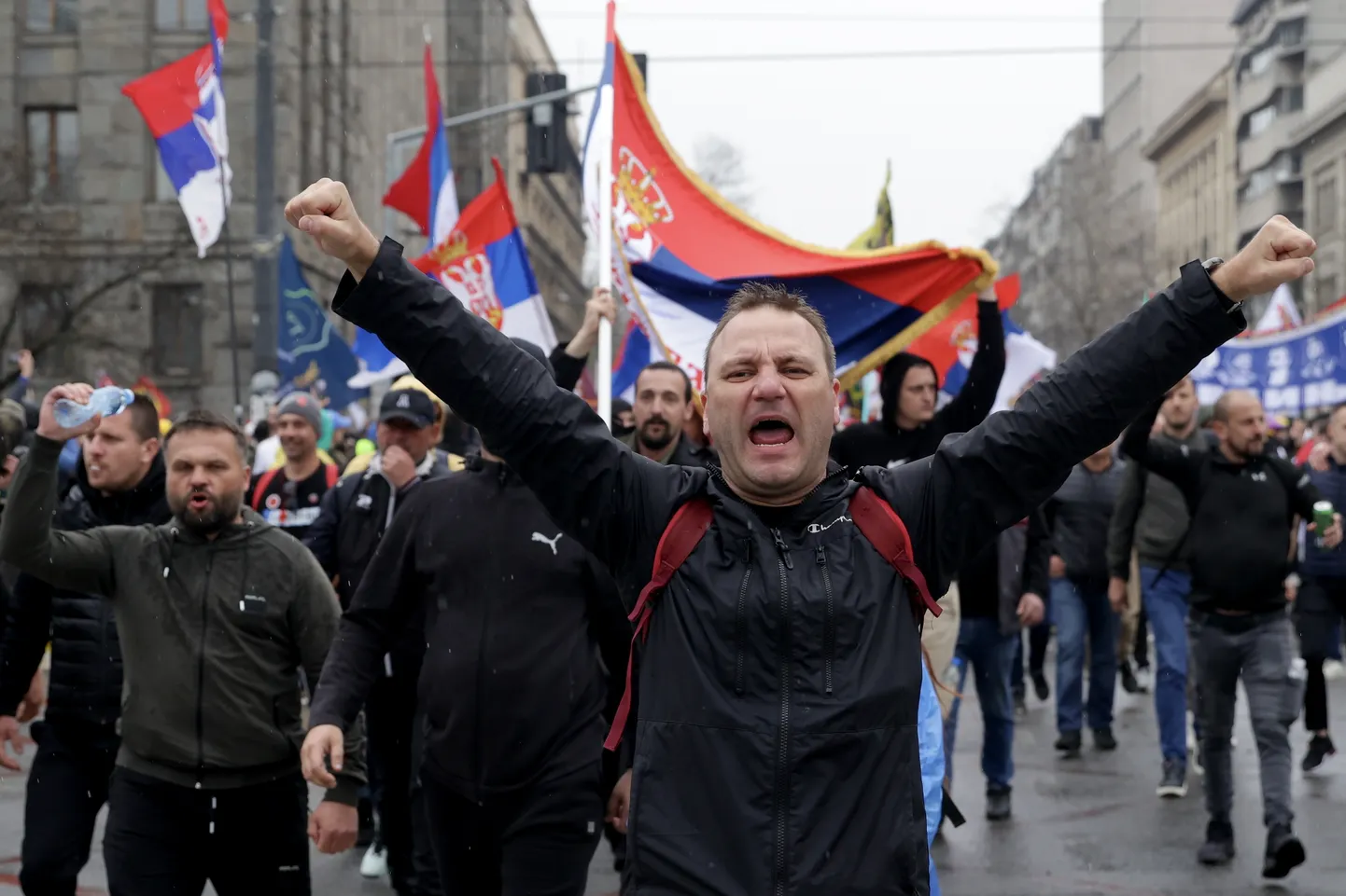 Protestētāji kliedz saukļus un vicina Serbijas karogus studentu vadītā mītiņā Belgradā, Serbijā, 2025. gada 15. martā.