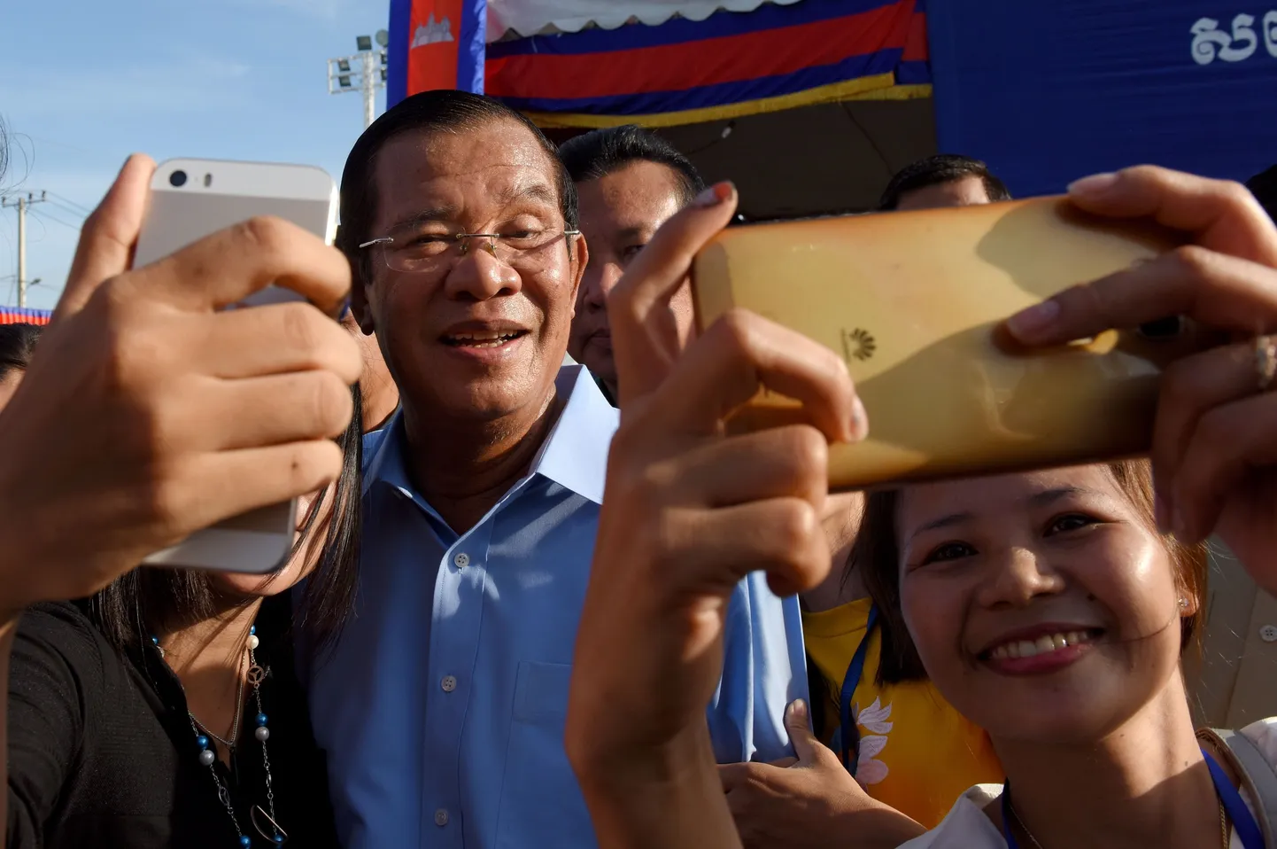 Kambodža peaminister Hun Sen poseerib Phnom Penhi tekstiilivabriku töölistele.