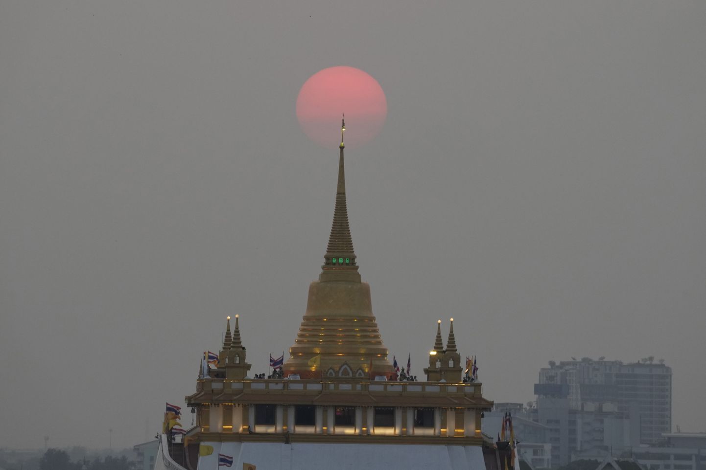 Päike loojumas Bangkoki templi taha.