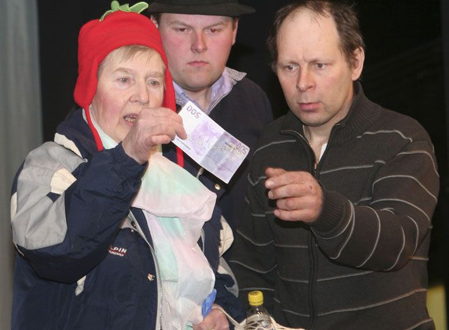 Räime Reet (Ene Pihol, vasakult), lõõtsamees Kalev Pallon ja pubiline Margus Liiman 500eurost valeraha tuvastamas Läsna rahvamaja lavastuses “Pulli Pubis”.