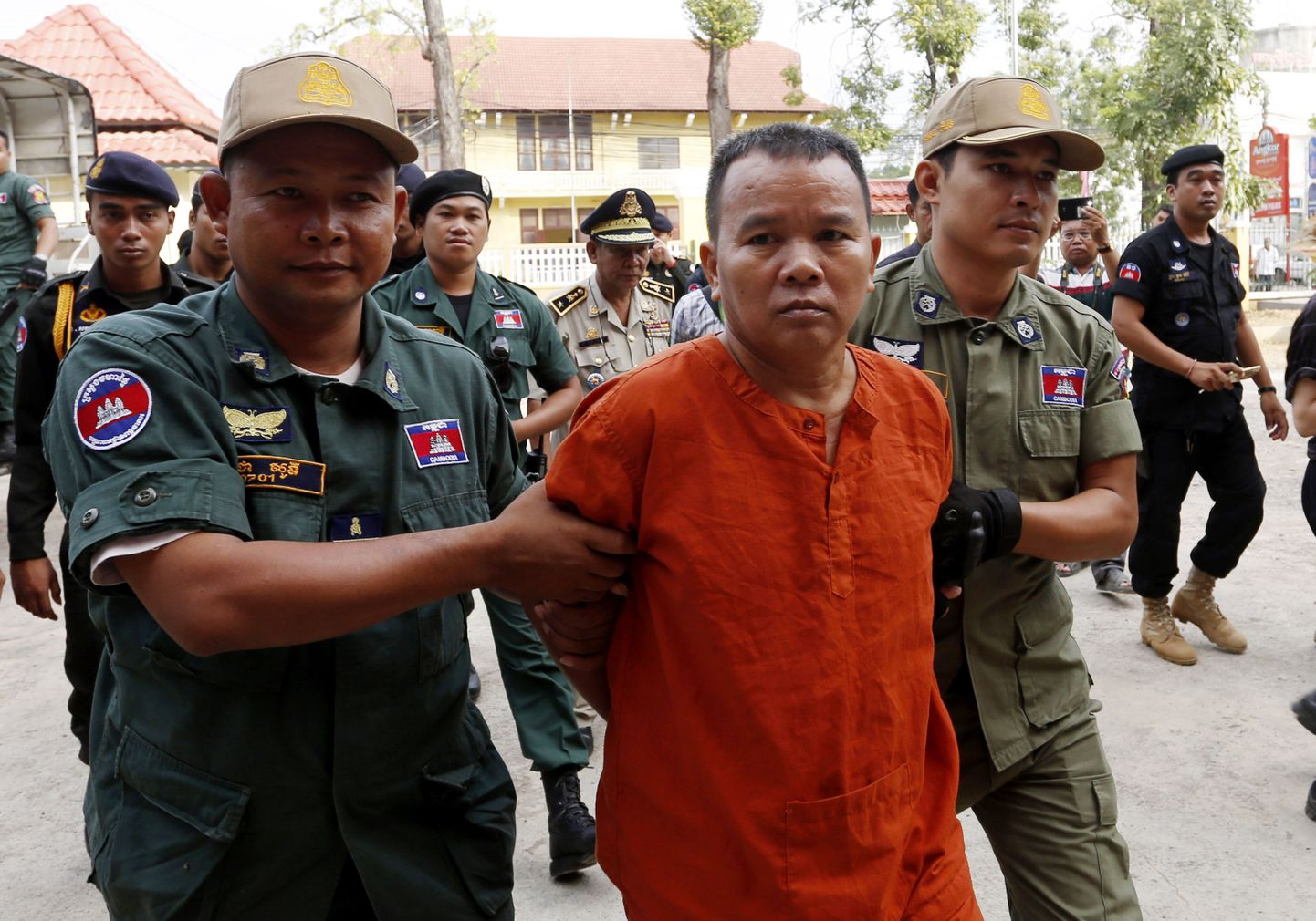 Litsentseerimata arst Yem Chrin eskorditakse Battambangi maakonnakohtusse.