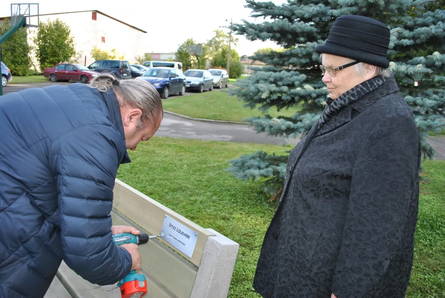 Muuga spordihoone juht Vaimar Abel kruvib nimelisele pingile sildi, pealt vaatab päevakangelane Ilma Lausvee.