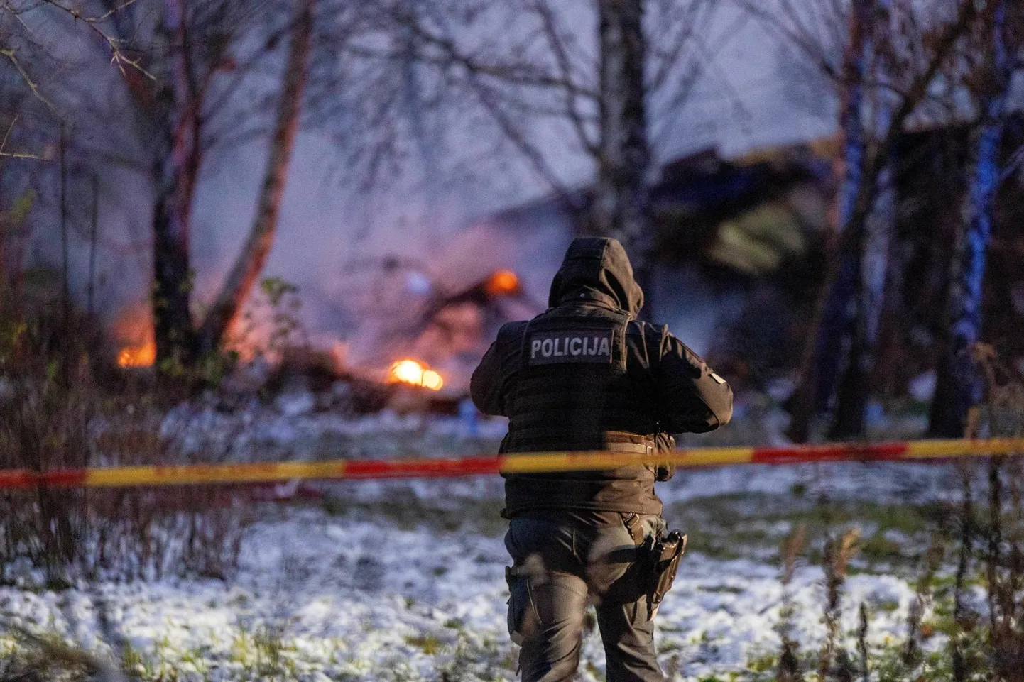 Leedu politseinik põleva lennukivraki juures Vilniuse äärelinnas.