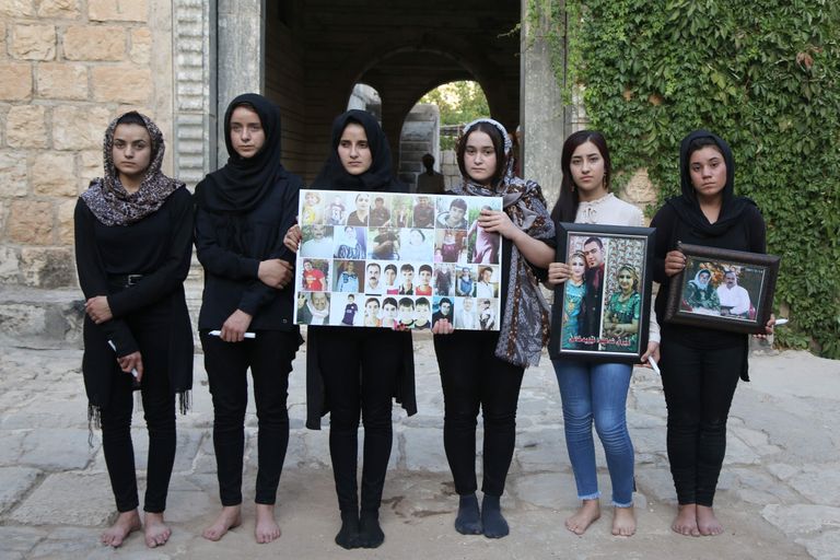 Ashwaq Haji Hami ja teised Islamiriigi seksiorjusest pääsenud naised näitamas hukkunud jeziidide fotosid
