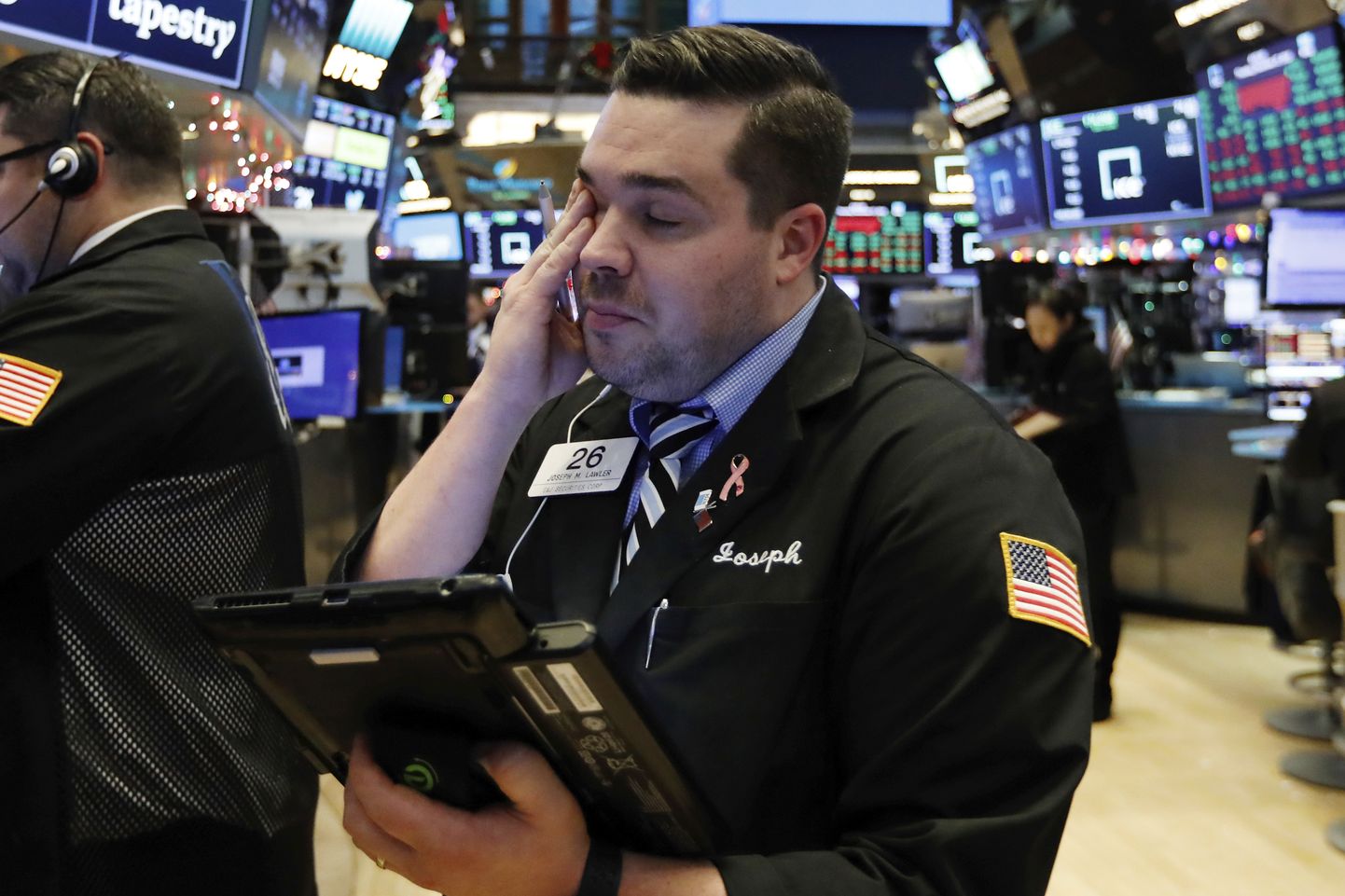 Trader Joseph Lawler works on the floor of the New York Stock Exchange at the closing bell, Thursday, Dec. 27, 2018. U.S. stocks staged a furious late-afternoon rally Thursday, closing with gains after erasing a 600-point drop in the Dow Jones Industrial Average. (AP Photo/Richard Drew)