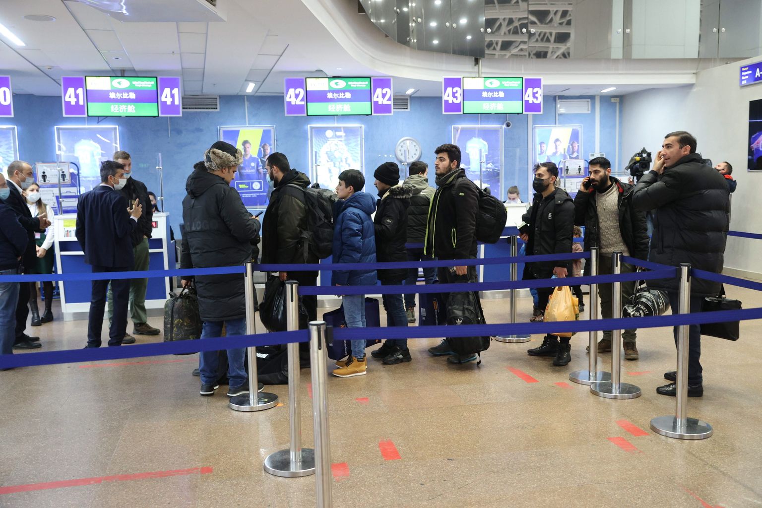 Migranti no Irākas valsts lidostā ārpus Minskas.