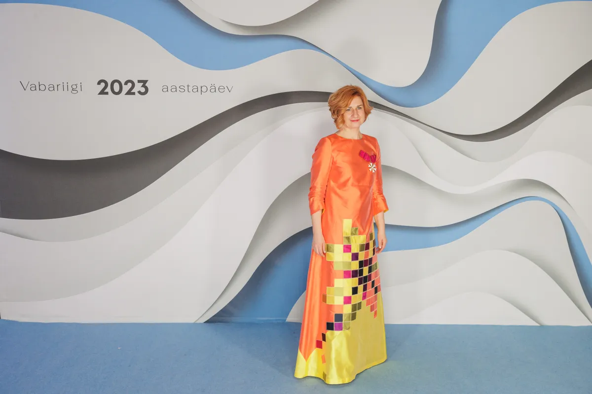Poliitik Lavly Perling särab vastuvõtul väärikas ja samas väga elujaatavas gammas Katrin Kuldma kleidis, mida ehib Eesti rahvusliku motiivi digitaalne stilisatsioon. See on meie vabaduse tähistamise päev, värvid on enam kui kohased!