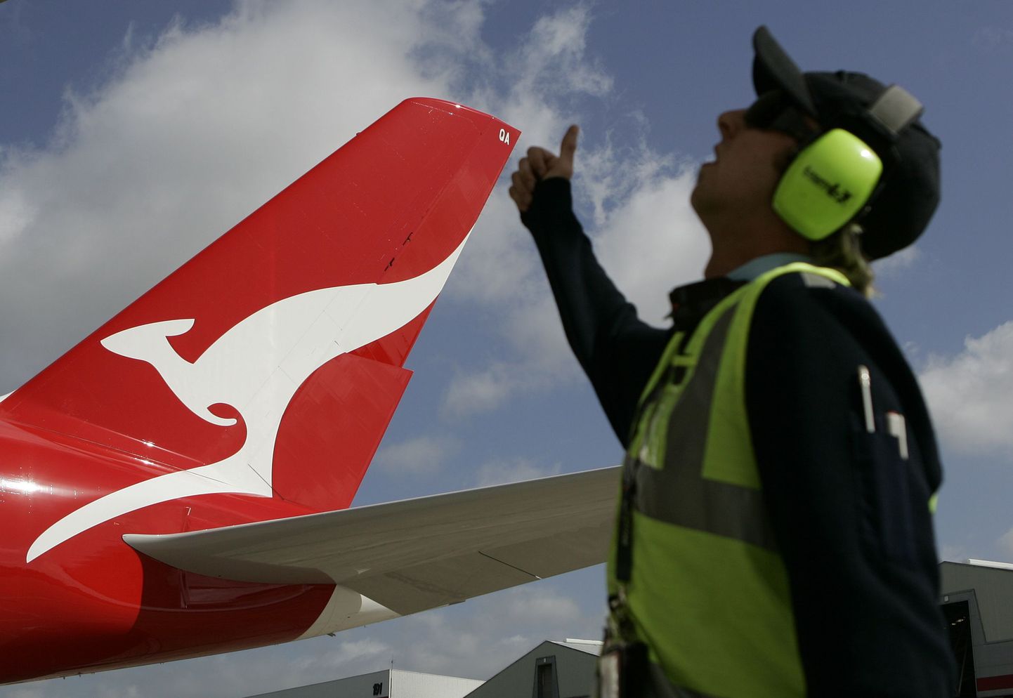 Qantase lennuk ja Sydney lennuvälja tehniline töötaja.