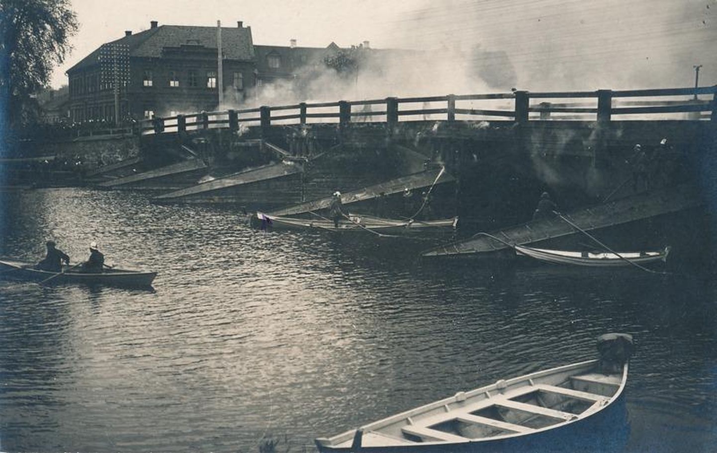 Süttinud silla kustutamine Emajõel 22. juunil 1923. Kiivrites tuletõrjujad on nii paatides kui ka sillal ja selle all.