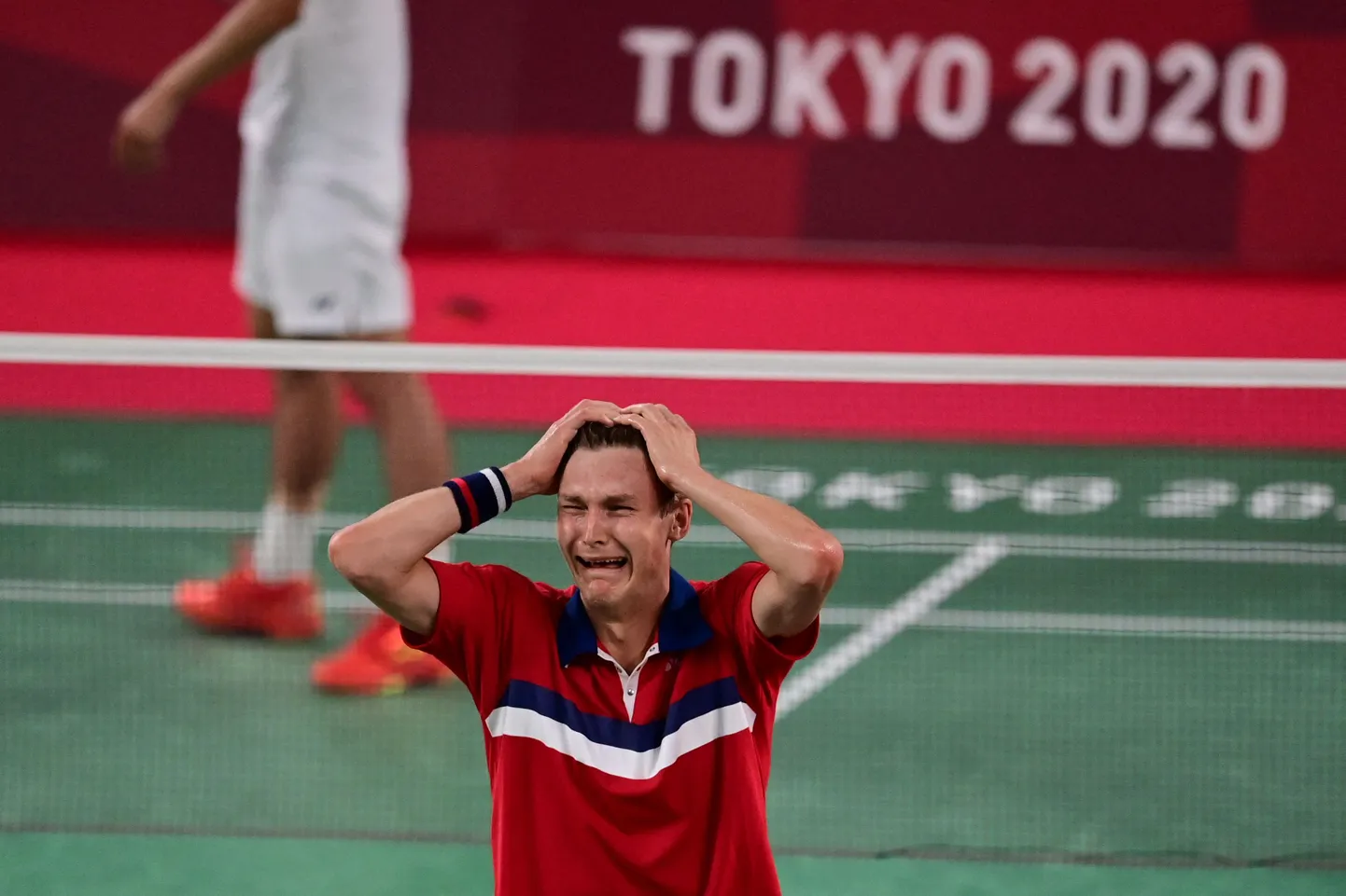 Viktor Axelsen on löönud viimase palli vastase väljakupoolele maha ja rõõmustab olümpiavõidu üle.