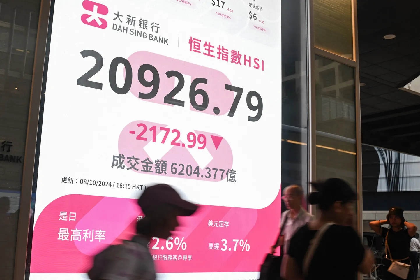 Jalakäijad möödumas Hang Sengi indeksi numbreid näitavast märgist Hongkongis 8. oktoobril 2024.