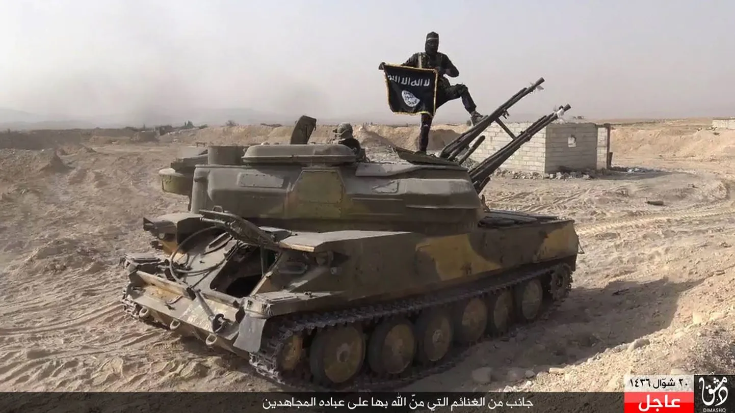 Islamiriigi võitleja seisab IS-i lipuga Süüria valitsusvägede tankil.