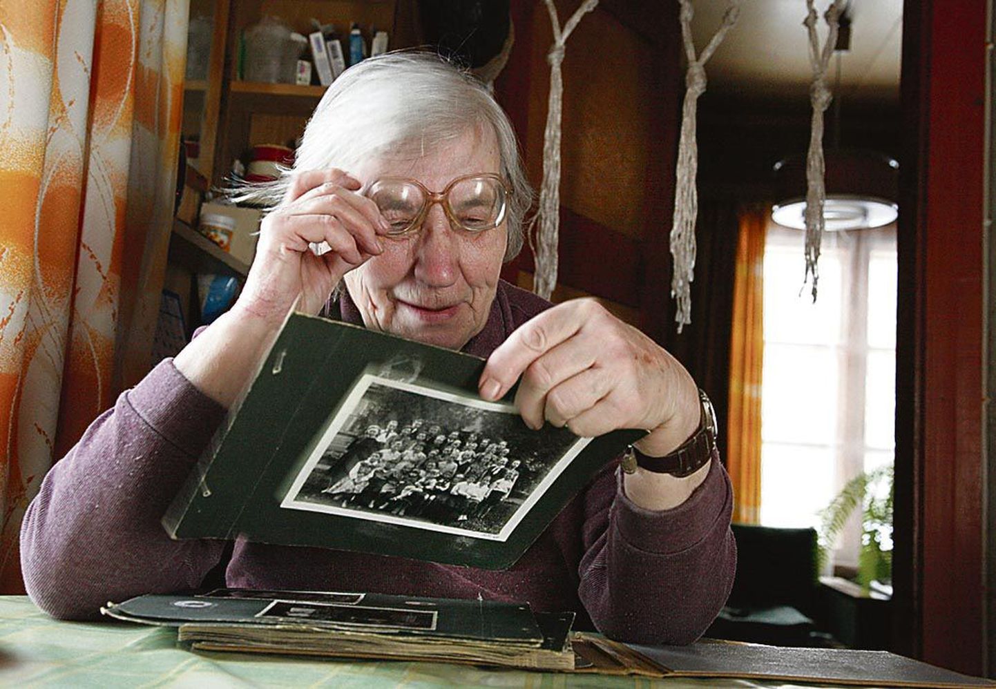 Kikerpera talu köögis uurib Eda Kosenkranius fotosid ajast, kui ta oli pool sajandit tagasi elujõulises külas kooliõpetaja.