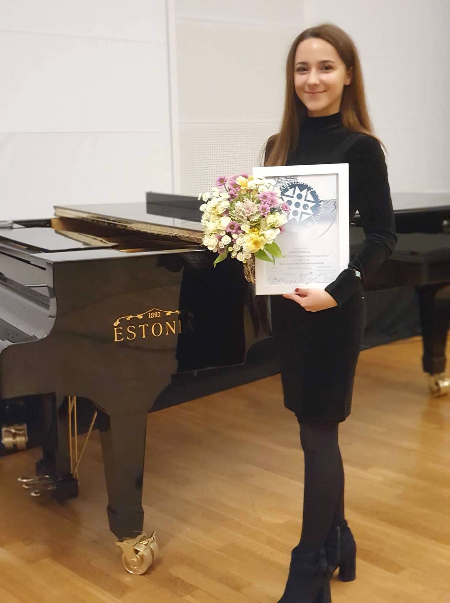 Diana Semikova ühes Eesti rahvuskultuuri fondi Heino Kaljuste sihtfondi preemiaga kaasas käiva diplomiga.