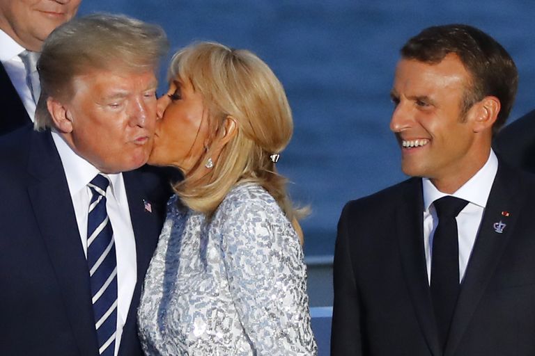 Prantsusmaa president Emmanuel Macron (paremal) vaatamas, kuidas ta naine Brigitte Macron annab põsemusi USA presidendile Donald Trumpile. Foto tehti 25. augustil 2019 Prantsusmaal Biarritzis G-7 riikide tippkohtumisel.