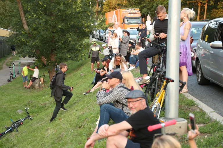 Зрители наблюдают за концертом Rammstein за воротами Певческого поля