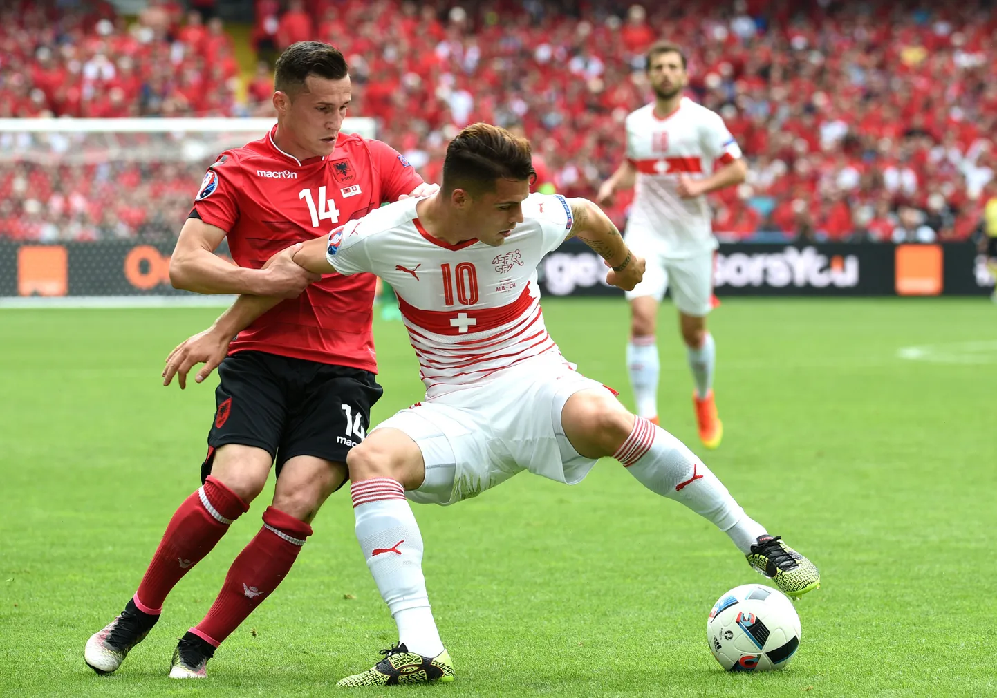 Vennad Granit (esiplaanil) ja Taulant Xhaka EMil omavahel heitlemas. Šveitsis sündinud meestest esimene esindabki palliväljakul Šveitsi, kuid tema vanem vend Taulant on selga tõmmanud Albaania särgi. Mõlema mehe juured viivad aga hoopis Kosovosse.