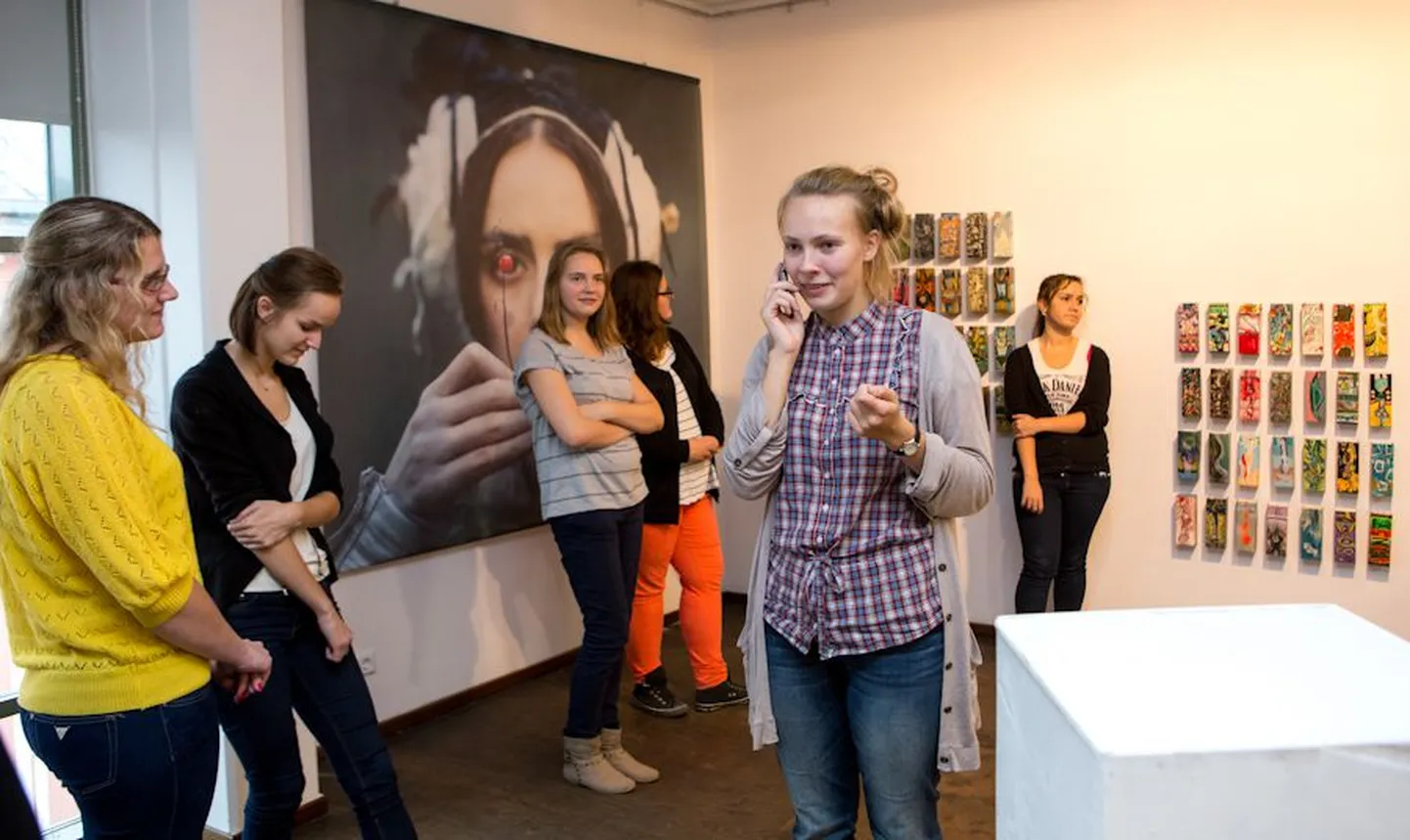 Noored kuraatorid Katrin Viinapuu, Kaisa Tiru, Merilyn Marjapuu, Rita Puhu, Anneli Tõnisson (Reta selja taga), Triin Ritval ja Adena Anton (jääb kaadrist välja) jälgivad pingsalt Reta Poolaku telefonivestlust kunstnik Erki Kasemetsaga, kes on saatnud näitusele maalingutega piimapakke oodatust väiksema koguse. Kunstnik soostub lisa saatma.