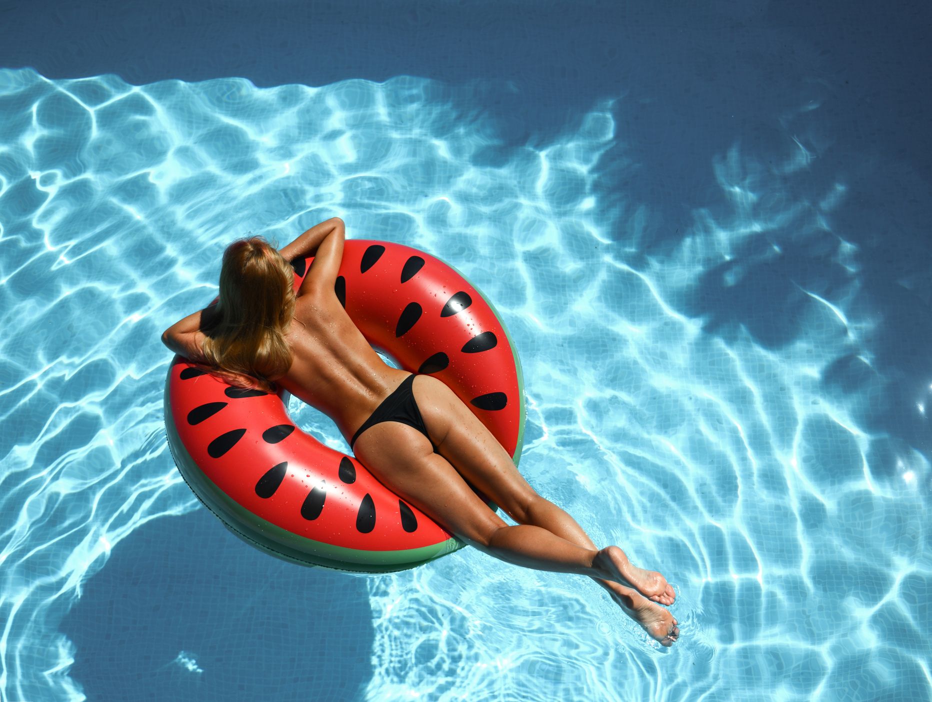 Topless naine kummirõngal basseinis. Pilt on illustreeriv