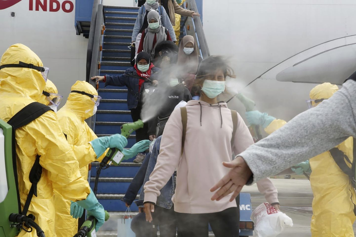 Uue koroonaviiruse epitsentrist saabunud turistide pritsimine antiseptikuga Indoneesias Batami lennujaamas.