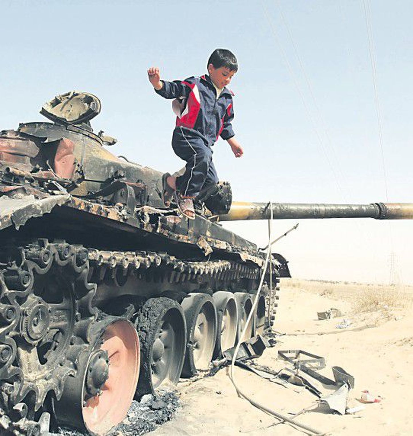 Ливийский ребенок играет на подбитом танке правительственных войск полковника Муаммара Каддафи, которые продолжают стрелять в свой народ.