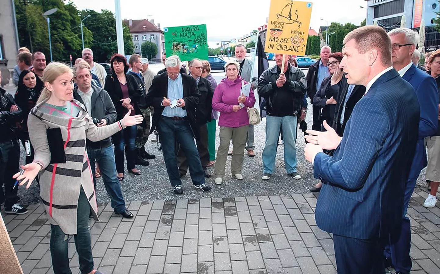 Raamatukogu ees ootas ministreid ligi poolsada piketeerijat, kes valitsuse pagulaspoliitikaga nõus ei olnud. Pildil diskuteerib pärnakas Triin Raidmets siseminister Hanno Pevkuriga, ministri varju jääb tema nõunik Väino Linde.