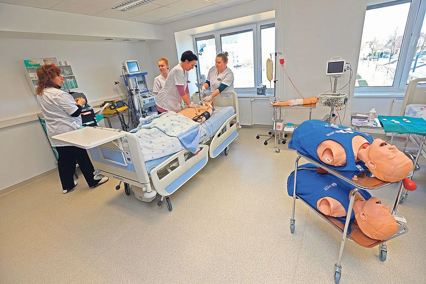 Tervishoiukõrgkooli uued eelkliinilise praktika ruumid on disainitud välja nägema nagu päris palatid, et tudengitel oleks haiglasse tööle minnes võimalikult lihtne. Pildil neiud õe õppekava kolmandalt kursuselt õppe-intensiivravipalatis nukk SimMani elustamas.