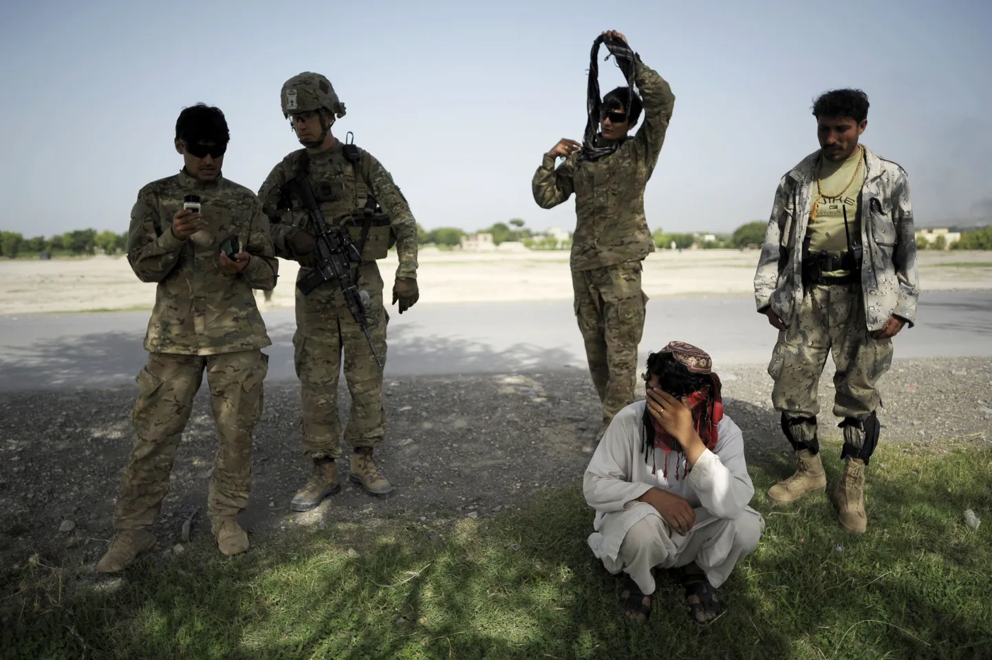 USA ja Afganistani sõdurid eile Khosti provintsis valvamas meest, keda kahtlustatakse mässuliste pommide kaugjuhtimisega plahvatama panemises.