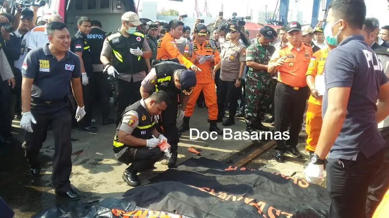 Päästetöötajad seismas lennuki vrakist leitud ohvrite kõrval. 