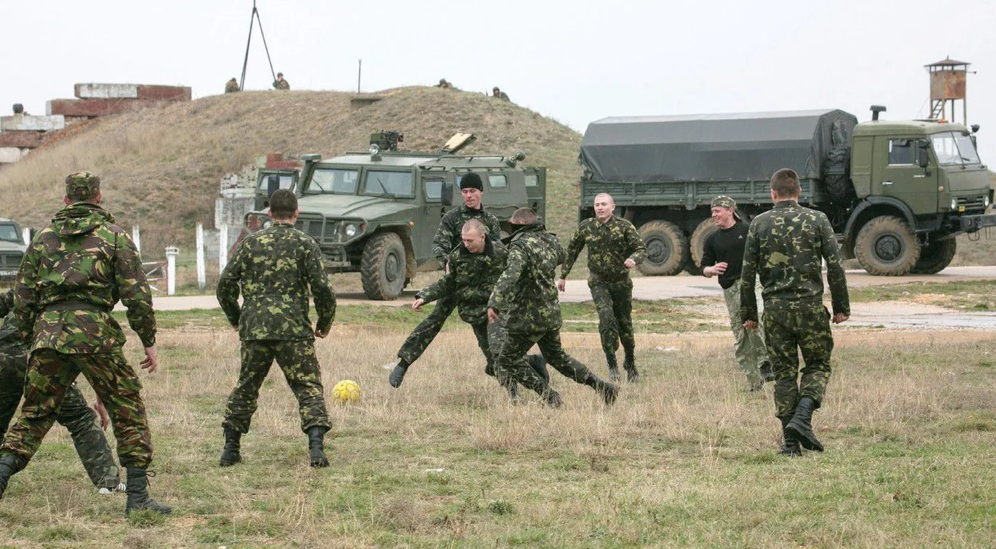 Мир или война? Украинские солдаты играют в футбол рядом с российскими военными машинами возле крымского аэропорта «Бельбек».